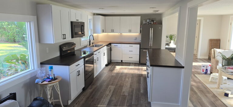 Custom white shaker kitchen cabinets with large island and under-cabinet lighting